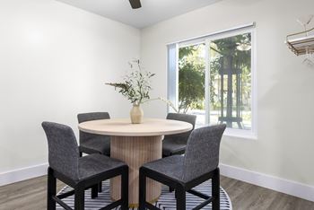 A dining room with a round table and chairs.